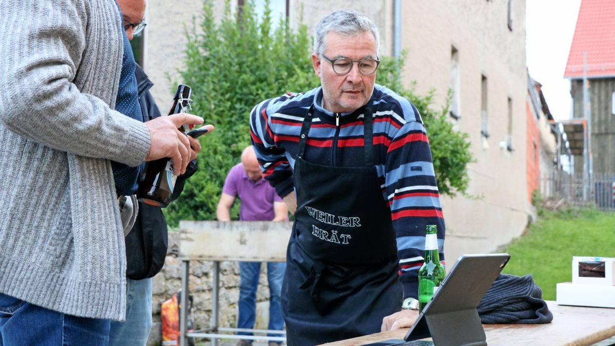 Bundestagskandidat Albert Weiler (Wahlkreis 195) sieht sich die ersten Ergebnisse vor dem Dorfgemeinschaftshaus in Zimmritz an, wo er für Freunde und Bürger den Rost angeworfen hat.