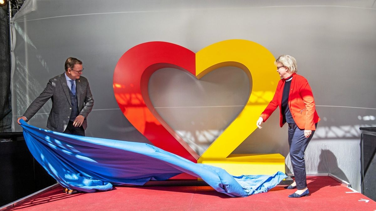 Ministerpräsident Bodo Ramelow (Linke) und Beauftragte Bärbel Grönegres enthüllen das Logo für die Bundesratspräsidentschaft nebst Einheitsfest. Dazu gehört in der Regel noch eine schwarze 