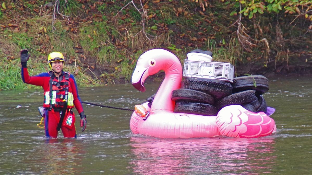 Zum Abtransport des im Fluss geborgenen Mülls wurden Muskelkraft, Bote und Schwimmtiere eingesetzt. DLRG-Helfer Hannes Zöllner grüßt vom geräderten Flamingo.