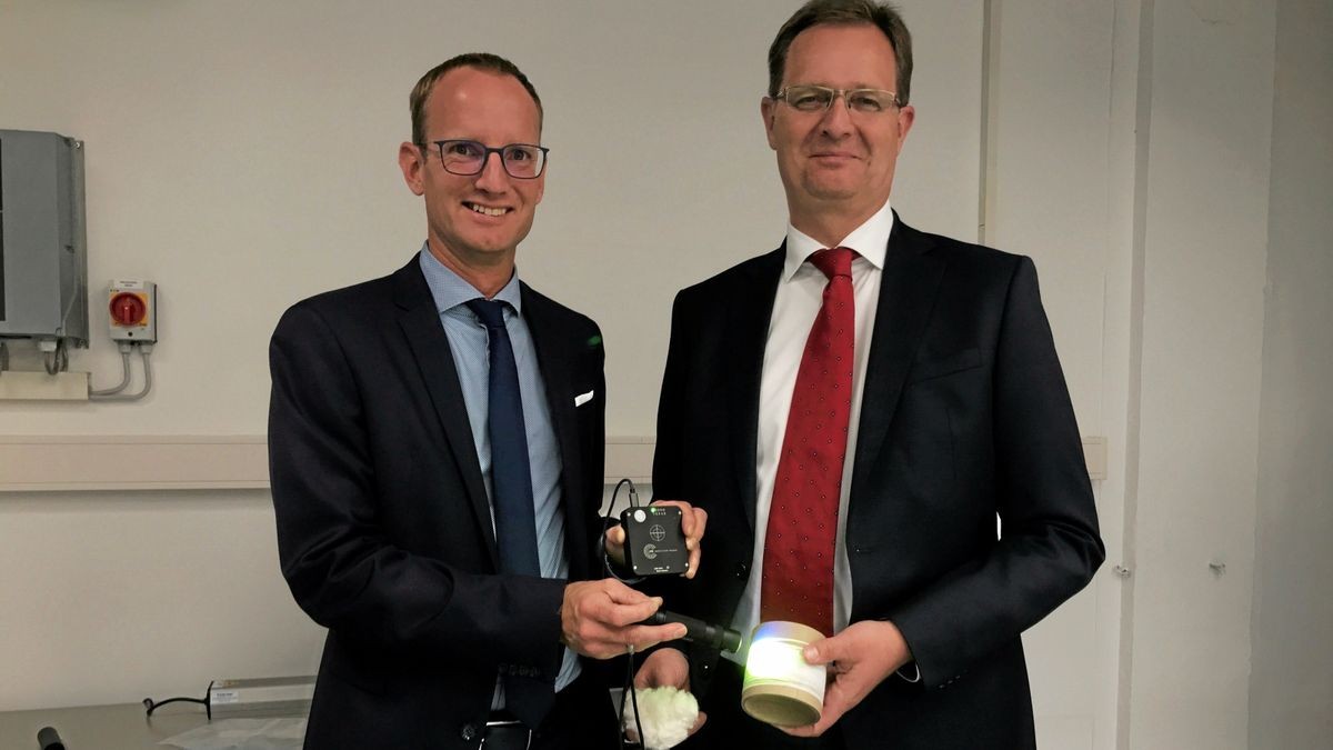 Dominik Uhlich (links) und Wolfgang Eisenberg präsentieren den Scanner, der die lumineszierenden Pigmente im Stoff ausliest.