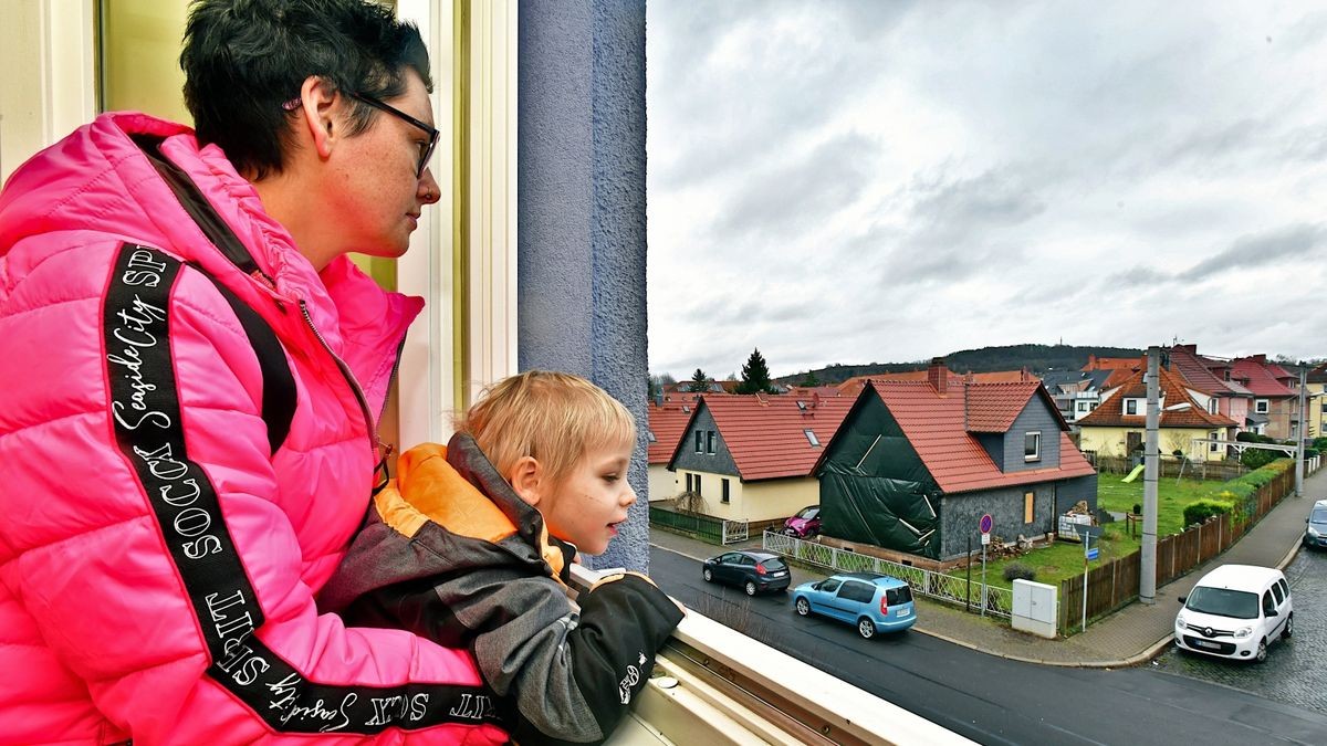 Die vierfache Mutter Antonia Schiller schaut mit ihrem sechsjährigen Kind Justo-Paul aus der Übergangswohnung auf das brandgeschädigte Fachwerkhaus aus dem Jahr 1918. Zum Glück ist das Haus versichert. 