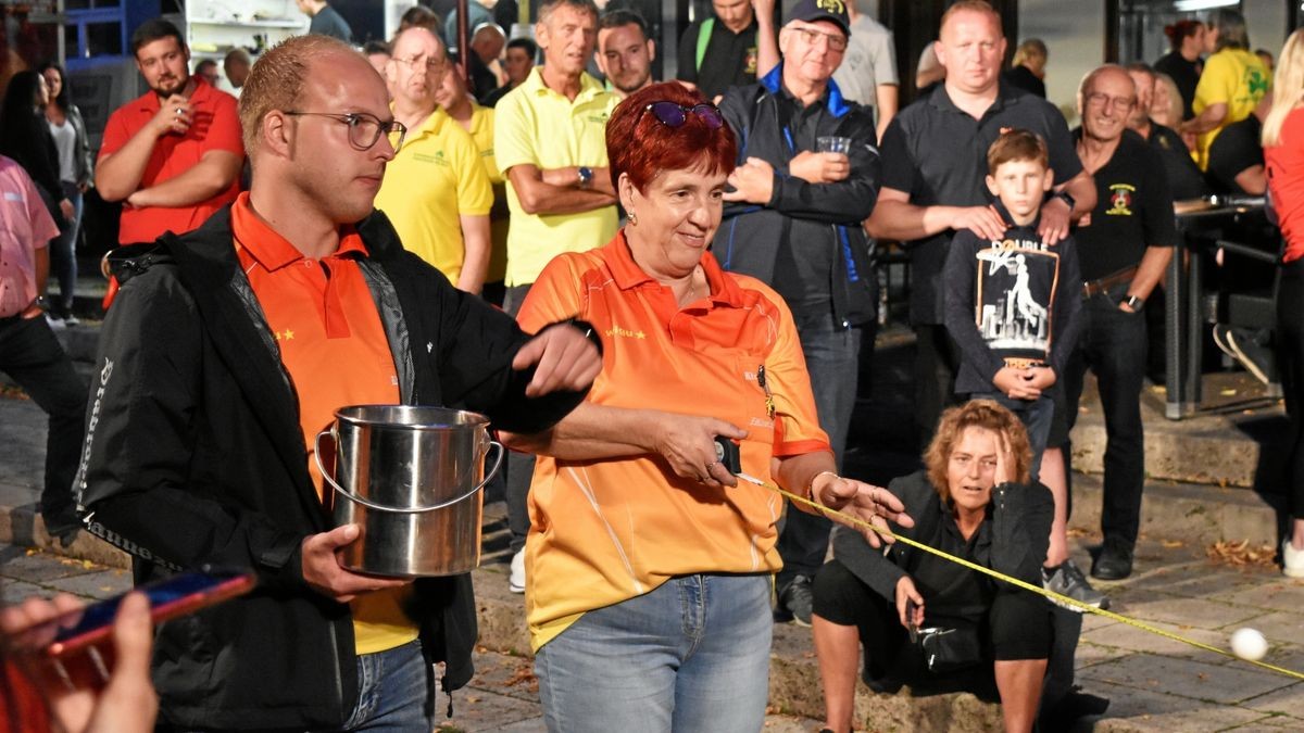 Mitglieder der Kirmesgemeinde Zöllnersgasse sind höchst konzentriert beim Jonglieren mit dem Ball auf dem Bandmaß.