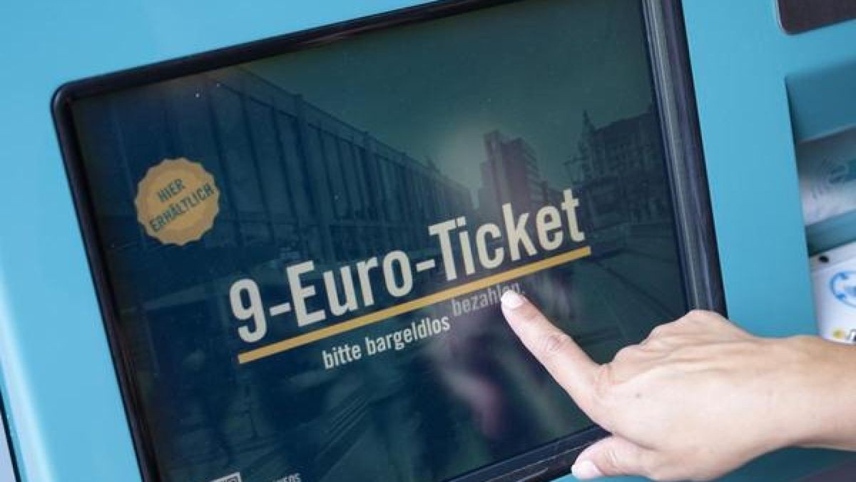 Eine Frau zieht sich an einem Fahrschein-Automaten ein 9-Euro-Ticket.