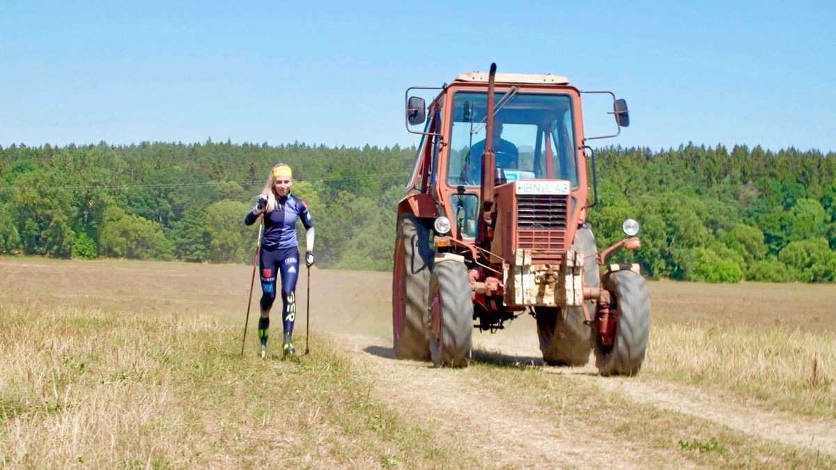 Um für besondere Thüringer Bauernhöfe zu werben, ließ das Thüringer Infrastrukturministerium Spitzensportler auf diesen Höfen trainieren und das in Drei-Minuten-Videos festhalten. Im Bild: Langläuferin Lisa Lohmann liefert sich auf der Kuhweide der Milch-Land GmbH Veilsdorf ein Rennen mit einem Traktor.