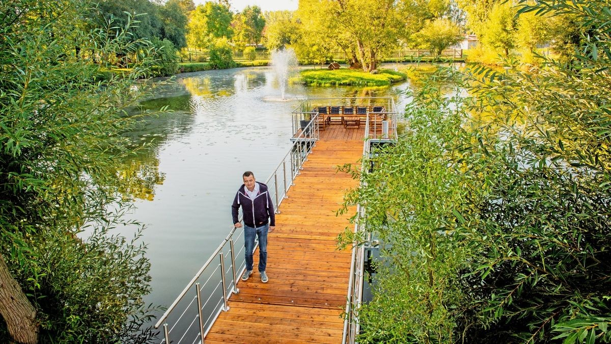 Merxlebens Bürgermeister Jan Edelhäußer präsentiert die schwimmende Plattform auf dem Teich des Bürgerparks.