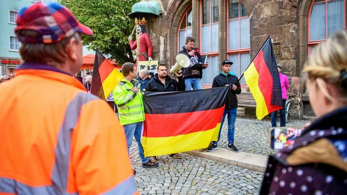 Mit Trillerpfeifen, Transparenten und Deutschlandfahnen beteiligen sich am Montagabend Hunderte Menschen an der Kundgebung auf dem Nordhäuser Marktplatz.