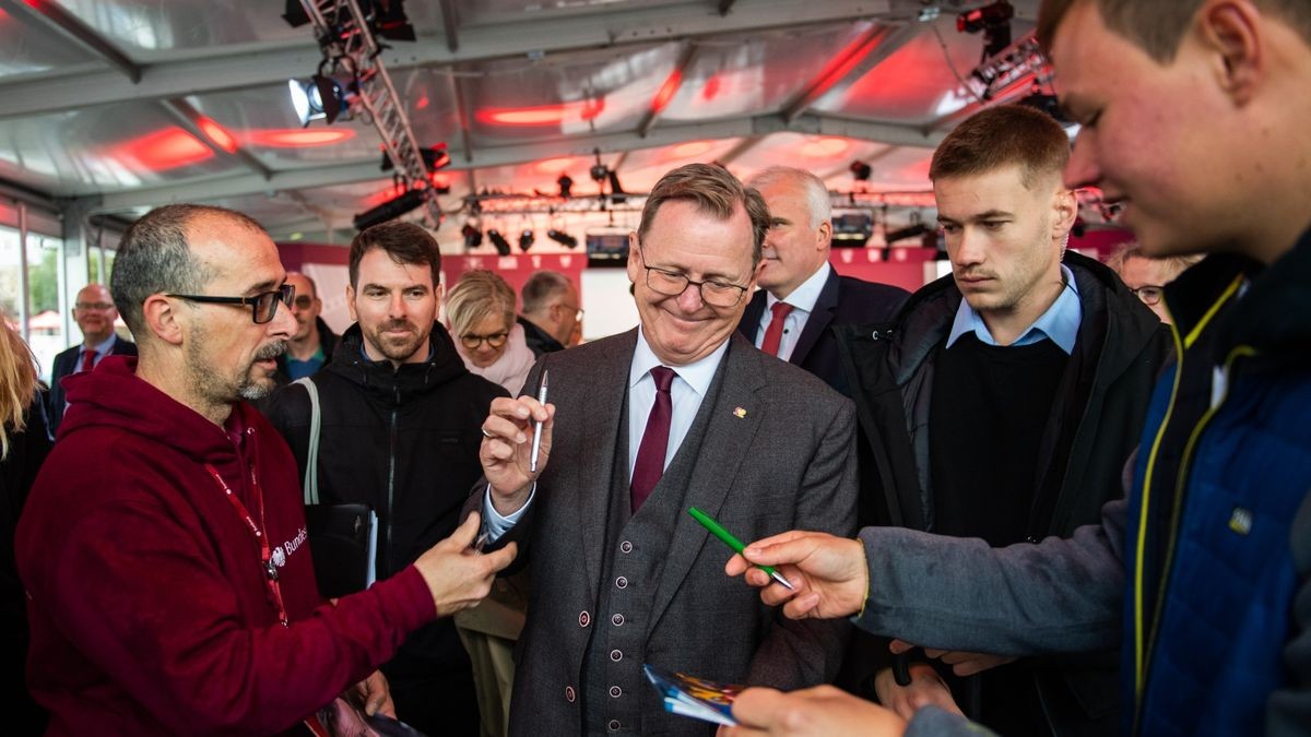 Ministerpräsident Bodo Ramelow (Die Linke) gibt Autogramme beim Rundgang auf dem Domplatz.