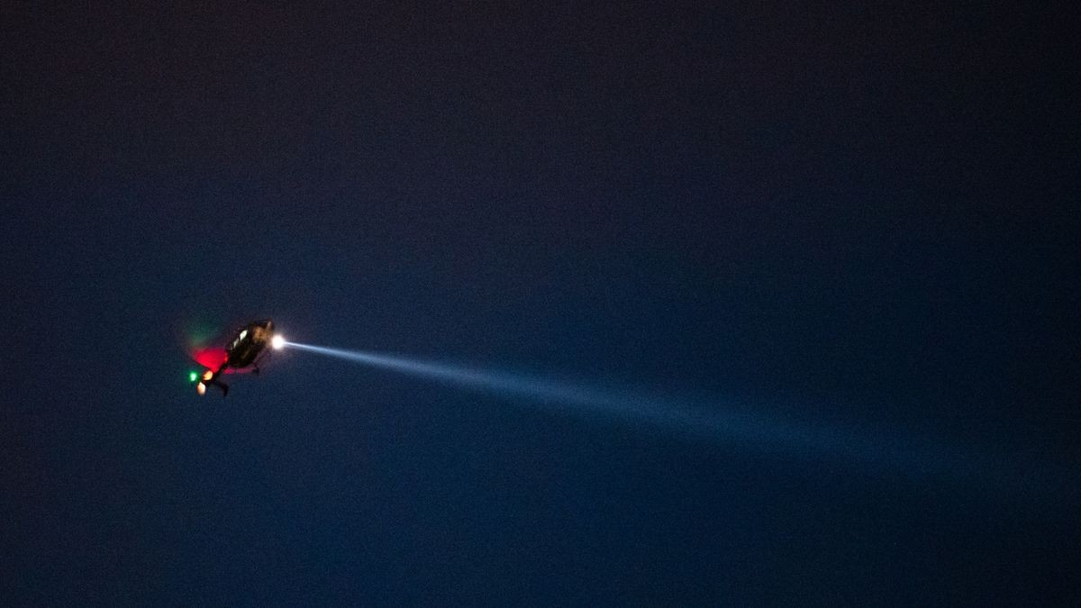 Ein Polizeihubschrauber am Abend am Himmel über der Innenstadt.