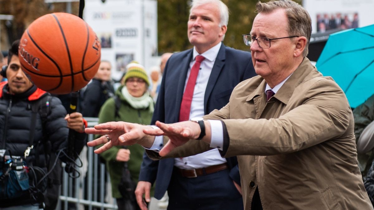 Ministerpräsident Bodo Ramelow (Die Linke) wirft einen Ball bei einem Spiel am Stand des Bundesrates auf dem Domplatz zu Beginn der Feierlichkeiten zum Tag der Deutschen Einheit.