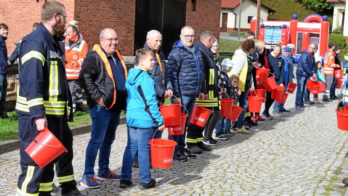 Pascal Marth (links) aus Günterode übernahm bei der Löschkette wie anno dazumal, das Wasser aus dem Eimer auf die Flammen zu befördern. Die Gäste hatten viel Spaß.