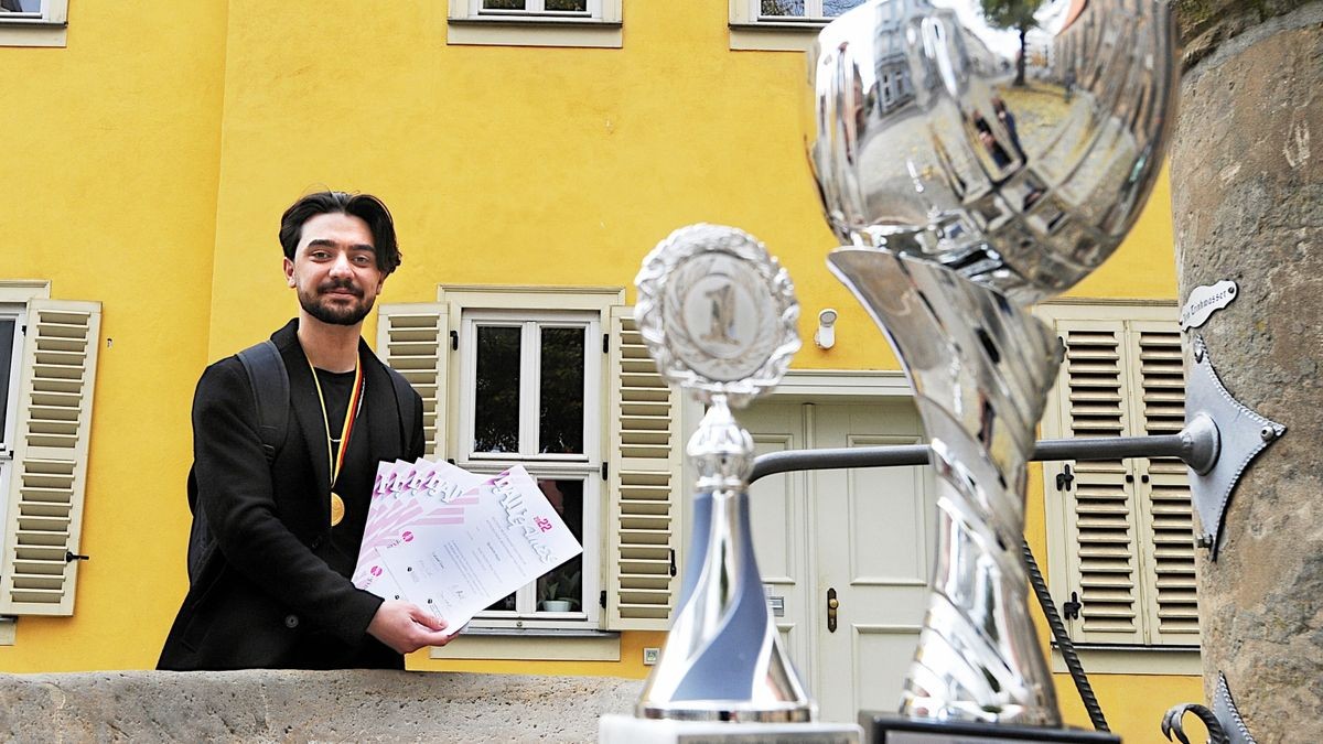 Ibrahim Haje  mit Pokalen, Urkunden und Medaille von der Deutschen Meisterschaft für Friseur-Azubis vor dem Diakoniewerk in der Augustinerstraße, wo er vor vier Jahren auch in Gotha ankam.