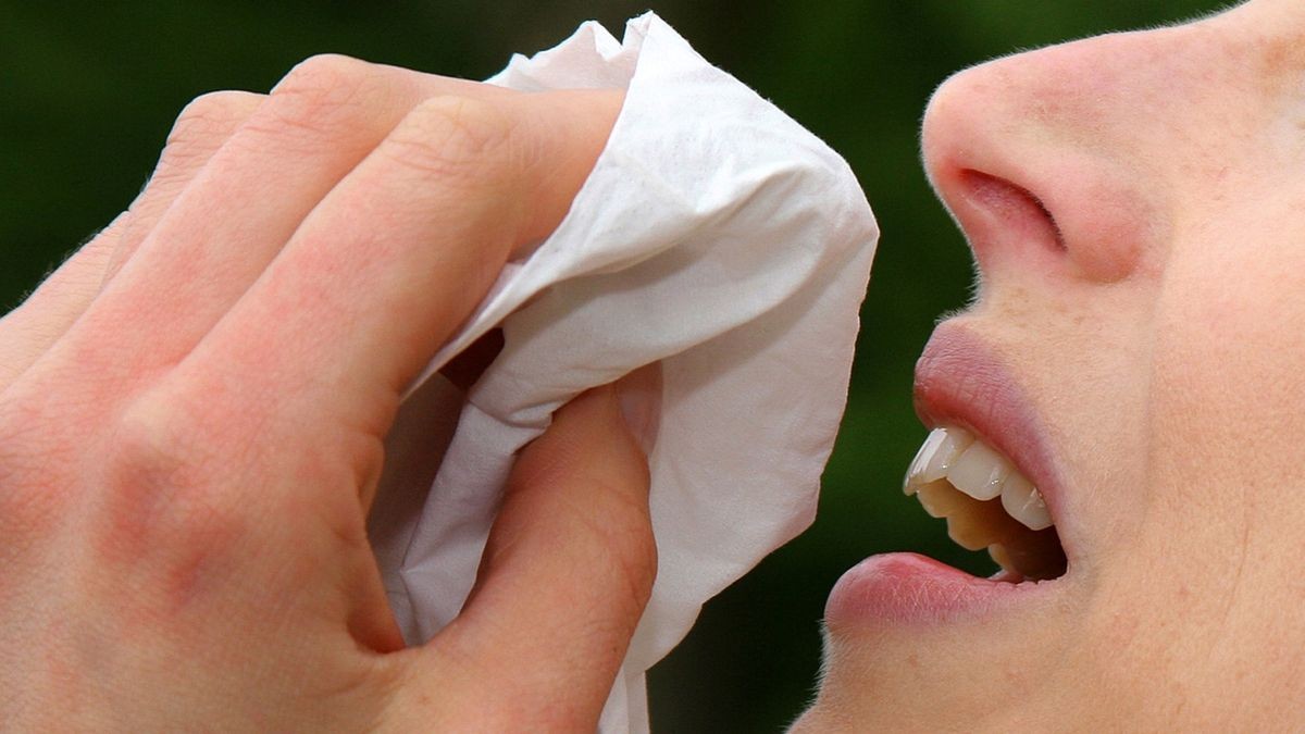 Eine junge Frau putzt sich mit einem Papiertaschentuch die Nase. Bisher wurden in dieser Saison 120 Influenza-Fälle in Thüringen gemeldet.