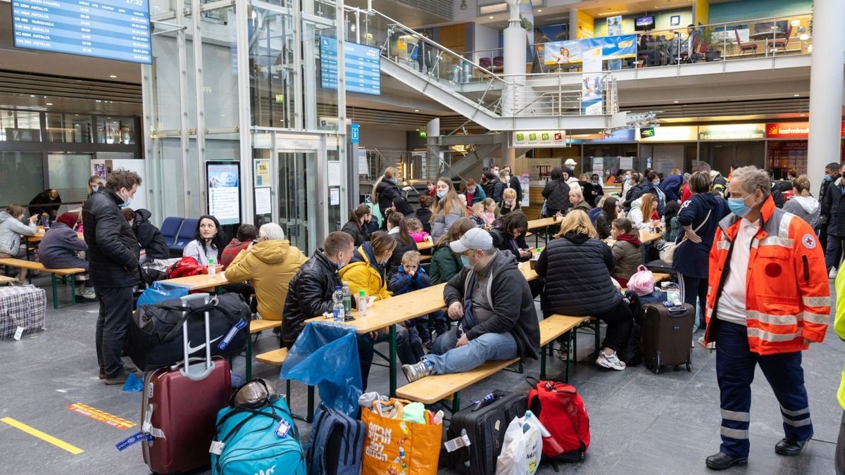 Geflüchtete aus der Ukraine sitzen nach der Ankunft im Flughafen Erfurt-Weimar und werden von Helfern betreut (Archivfoto).