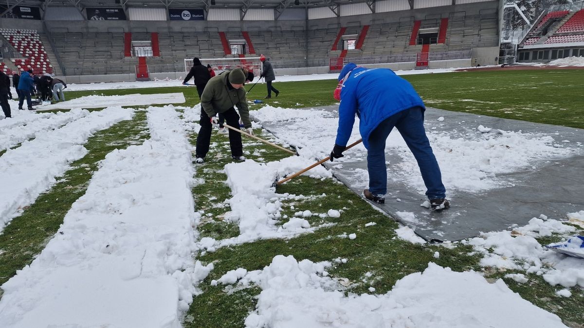 Das Fußball-Spielfeld für das am Sonntag stattfindenden Spieles RWE vs. Energie Cottbus sollte von den Freiwilligen von den Schneemaßen beräumt werden.