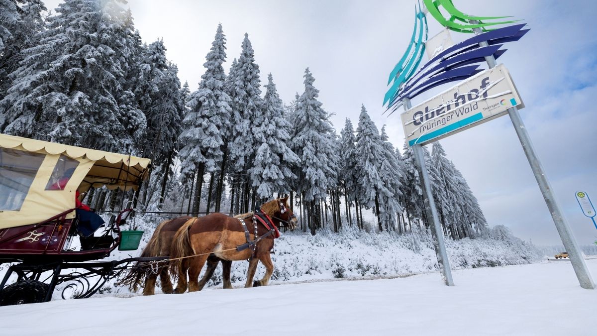 Eine Pferdekutsche fährt an einem Schild vorbei, das für Oberhof im Thüringer Wald wirbt. Hier soll am 17. Dezember 2022 die Abfahrt-Skisaison eröffnet werden.