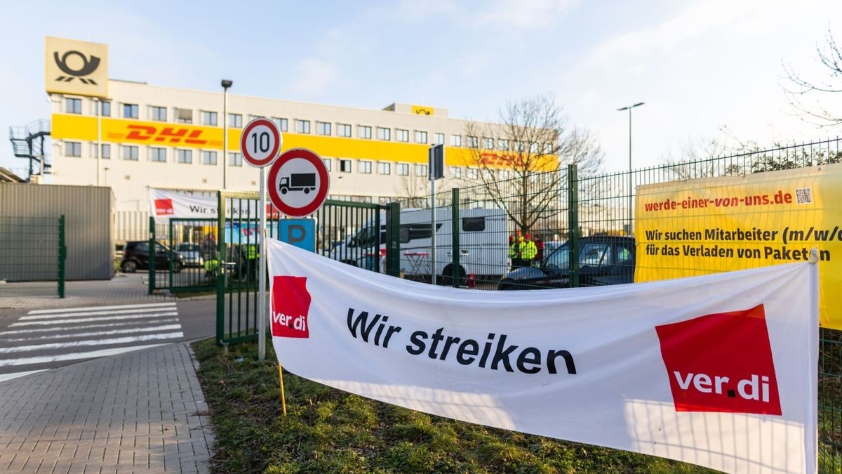 Ein Banner mit der Aufschrift «Wir streiken» hängt vor einem Gebäude des Paketdienstleisters DHL in Lahn.