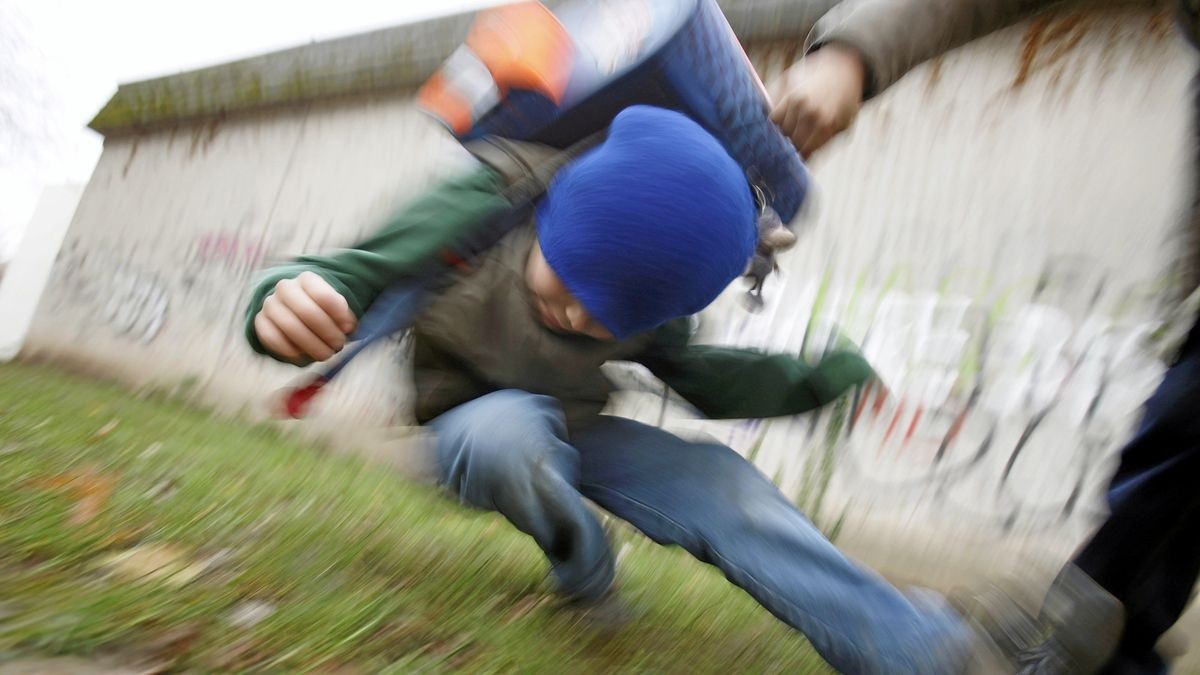 Ein Schüler drückt auf dem Schulhof eines Gymnasiums einen anderen Schüler zu Boden (gestelltes Illustrationsfoto). Die Mehrheit der Schüler in Deutschland hat einer Untersuchung zufolge Ausgrenzung, Hänseleien oder körperliche Gewalt erlebt. Schulsozialarbeiter können für Betroffene Ansprechpartner sein.