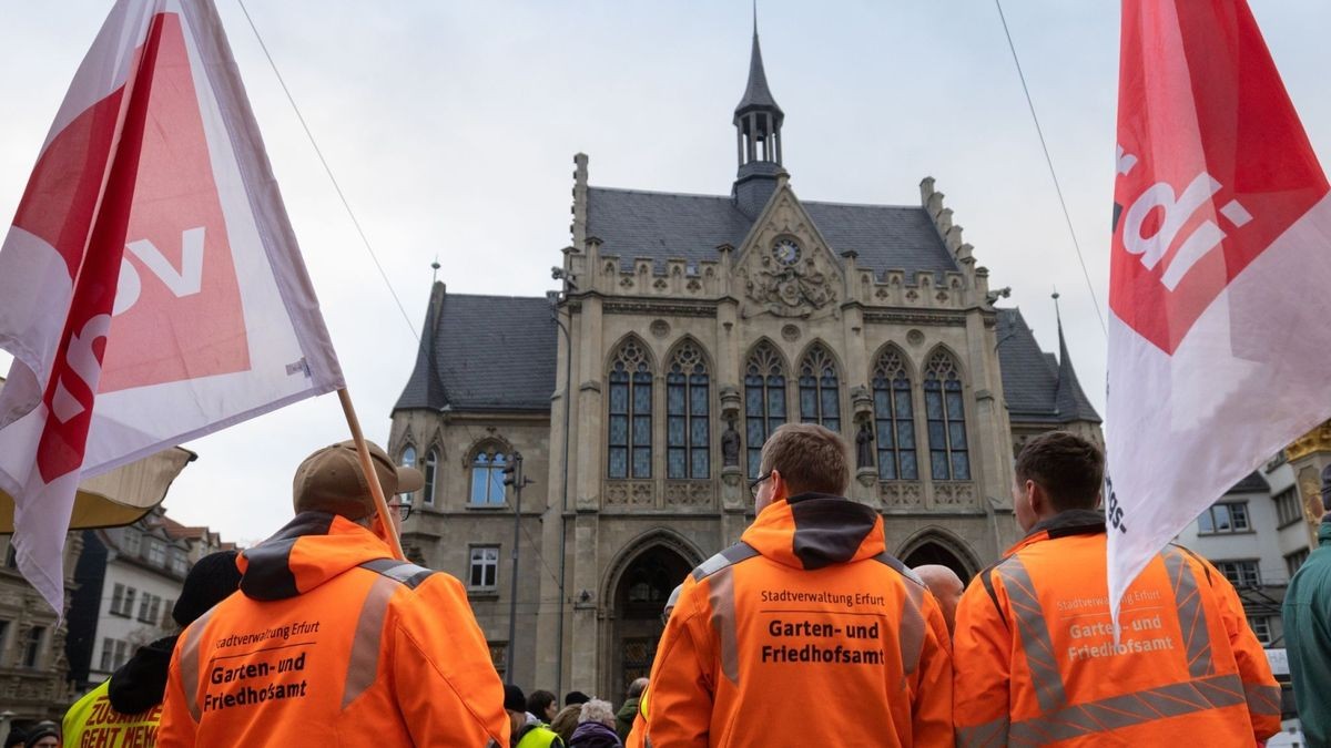 Demonstranten halten bei einem Warnstreik auf dem Fischmarkt Fahnen von Verdi.