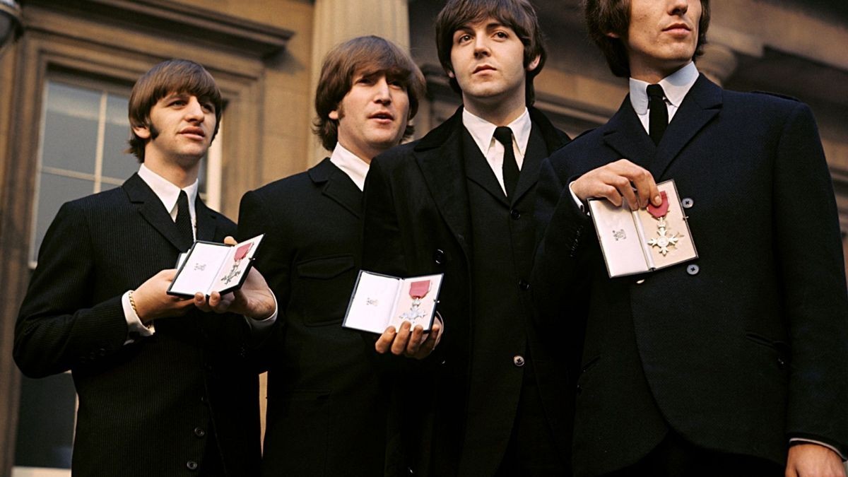 Ringo Starr, John Lennon, Paul McCartney und George Harrison zeigen ihre MBE-Insignien auf dem Vorplatz des Buckingham Palace, nachdem sie von Königin Elisabeth II. empfangen wurden.