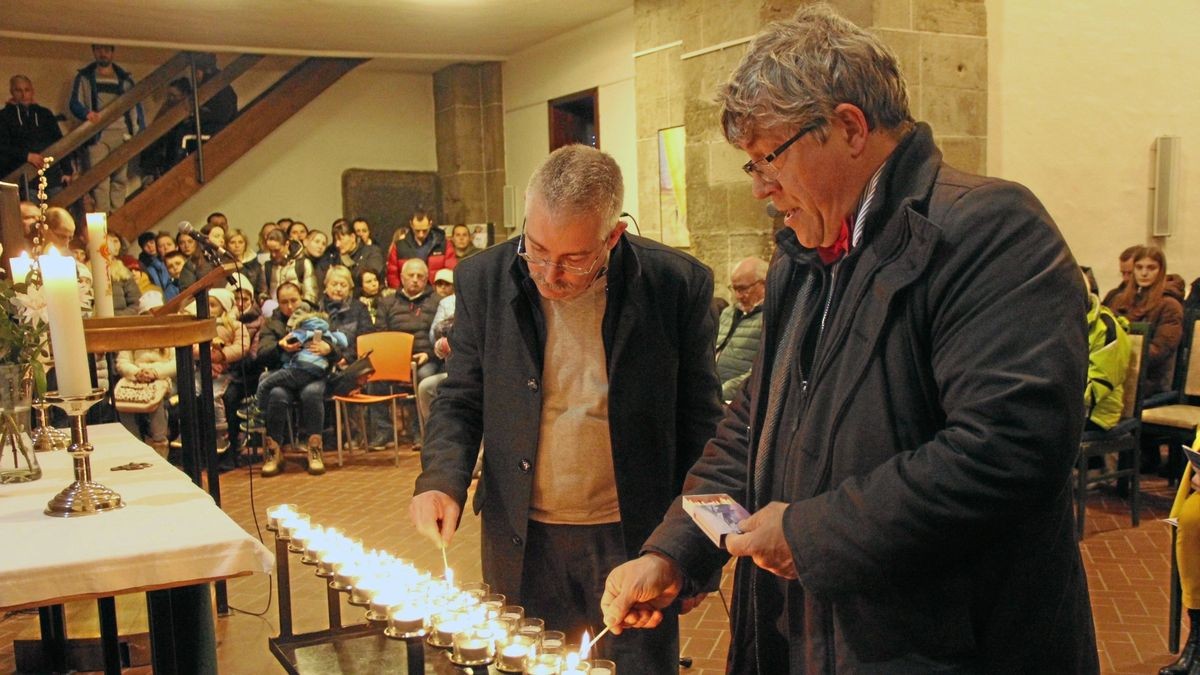 Landesbischof Friedrich Kramer (rechts) und Superintendent Andreas Schwarze entzündeten während des Friedensgebets dutzende Kerzen.