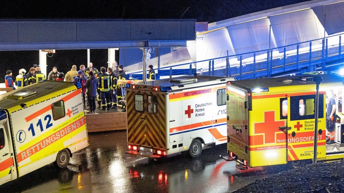 Rettungswagen und Helfer stehen am Abend des 23. Februar am Ausgang der Bobbahn. 