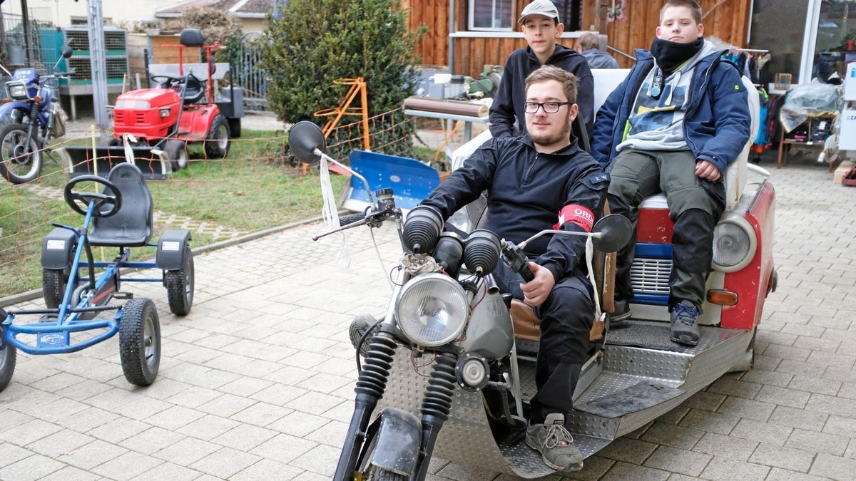 Robert Wolf (vorne) mit (hinten links) Tim Grau und Aaron Wolf auf dem Trike, das zur Hälfte aus einem Trabi und zur anderen Hälfte aus einem Motorrad besteht.