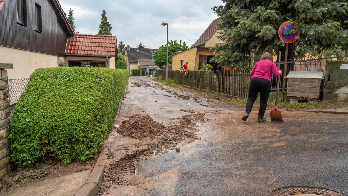 Mit Schaufeln und Besen versuchten Anwohner, ihre Grundstücke vom Schlamm und dem zurückgebliebenen Wasser zu befreien.