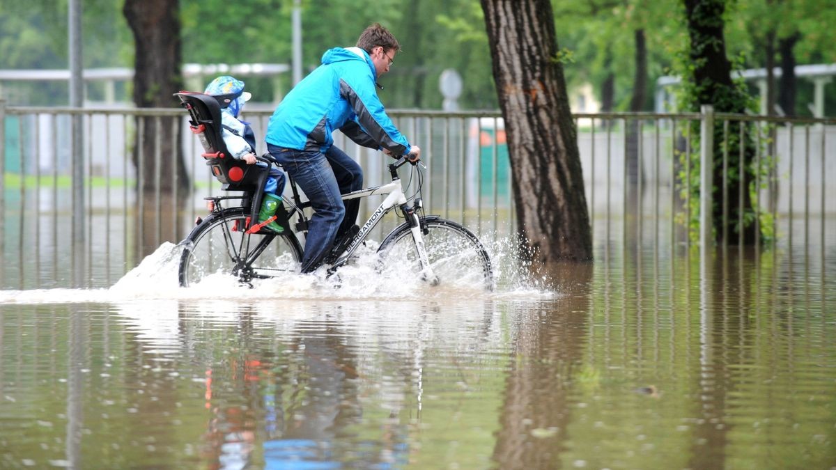 Mutige Radfahrer passieren die Fluten am Ernst-Abbe-Sportfeld.