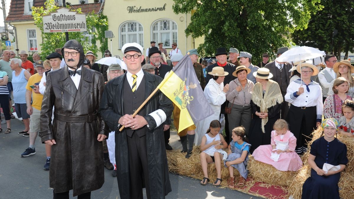 Der überwiegende Teil der rund 600 Fahrzeuge auf zwei, drei und vier Rädern, die an der Veranstaltung „Schleizer Dreieck 100“ anlässlich des Rennstreckenjubiläums teilnahmen, beteiligte sich am Samstagnachmittag bei der Nachstellung des historischen Starts von 1923. Über 70 Komparsen in Bekleidung der ersten Jahrzehnte des 100 Jahre alt gewordenen Schleizer Dreiecks standen nahe des Gasthauses Weidmannsruhe bei Schleiz-Oberböhmsdorf am Rand der Rennstrecke. Sie verfolgten wie Stadtarchivar Ingo Möckel den damaligen Rennleiter Johannes Wächter spielte und die Strecke freigab. Heimatgeschichtlicher Juergen K. Klimpke verkörperte den Schleizer-Dreieck-Entdecker Karl Slevogt, der in einem Apollo-Fahrzeug mitfuhr.