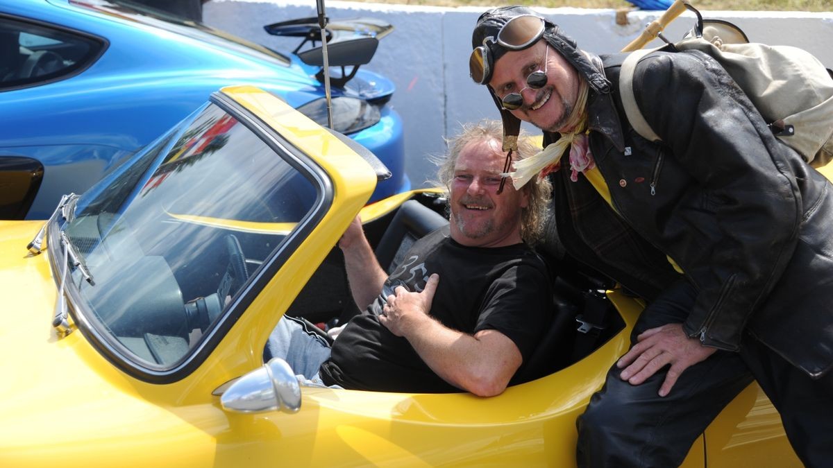 Marco Brauer (l.) aus Dornburg mit seinem Melkus RS2000, an dem Günter Weigert aus Plauen Interesse zeigt. Der überwiegende Teil der rund 600 Fahrzeuge auf zwei, drei und vier Rädern, die an der Veranstaltung „Schleizer Dreieck 100“ anlässlich des Rennstreckenjubiläums teilnahmen, beteiligte sich am Samstagnachmittag bei der Nachstellung des historischen Starts von 1923. Über 70 Komparsen in Bekleidung der ersten Jahrzehnte des 100 Jahre alt gewordenen Schleizer Dreiecks standen nahe des Gasthauses Weidmannsruhe bei Schleiz-Oberböhmsdorf am Rand der Rennstrecke. Sie verfolgten wie Stadtarchivar Ingo Möckel den damaligen Rennleiter Johannes Wächter spielte und die Strecke freigab. Heimatgeschichtlicher Juergen K. Klimpke verkörperte den Schleizer-Dreieck-Entdecker Karl Slevogt, der in einem Apollo-Fahrzeug mitfuhr.