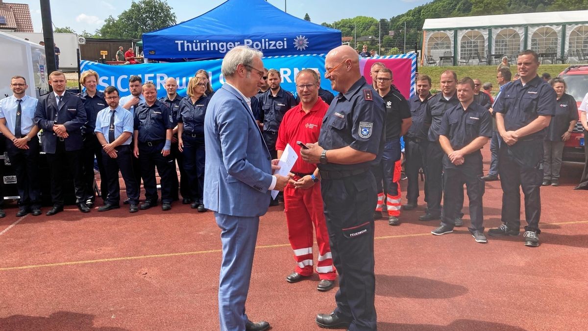 Thüringens Innenminister Georg Maier hat während des Thüringentages in Schmalkalden Einsatzkräfte und freiwillige Helfer für ihren Einsatz vor zwei Jahren im Ahrtal mit der Fluthilfemedaille des Landes Rheinland-Pfalz ausgezeichnet. Georg Maier (links) übergibt Dirk Niessner (rechts) und Daniel Saft (Mitte) stellvertretend für die Einsatzkräfte des Kreises Gotha die Fluthilfemedaillen samt Urkunden.    