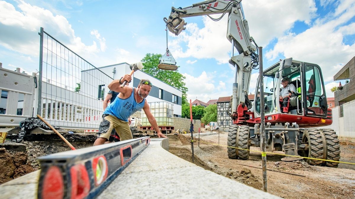 Danny Gründling und Maik Rüsgen (v.l.n.r.) von Granitbau beim Setzen der neuen Straßenbegrenzungssteine an der Wiedigsburg.