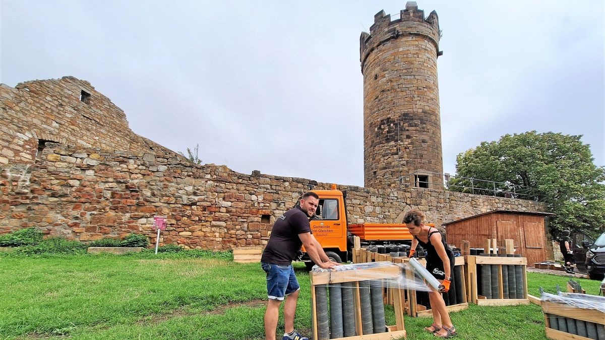 Florian Därr (links) und Sandra Lämmel ziehen auf dem Hof der Mühlburg Folie über eine mit Röhren bestückte Holzpalette. In den Röhren verbergen sich Kugelbomben. Sie müssen bis zum Abschuss zur Pyroshow beim Drei(n)schlag gut vor Feuchtigkeit geschützt werden.