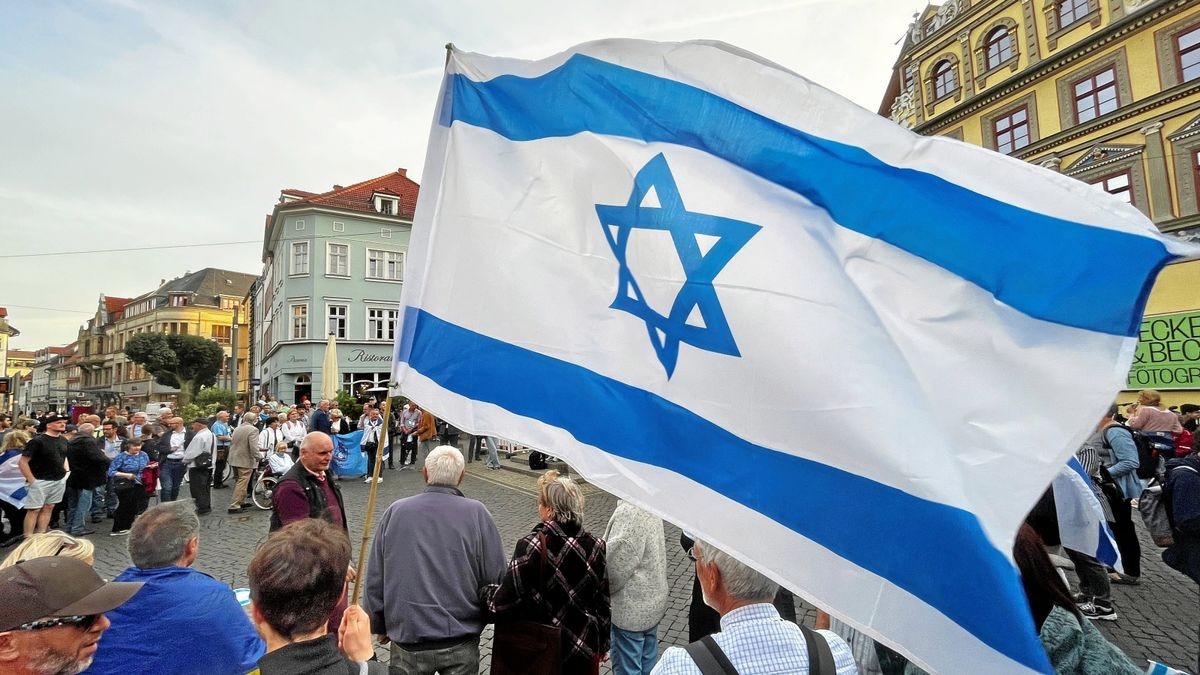 Hunderte Menschen sind am Mittwochabend zur Israel-Solidaritäts-Demo vor dem Erfurter Rathaus auf dem Erfurter Fischmarkt erschienen. Viele halten die israelische Flagge in der Hand. 