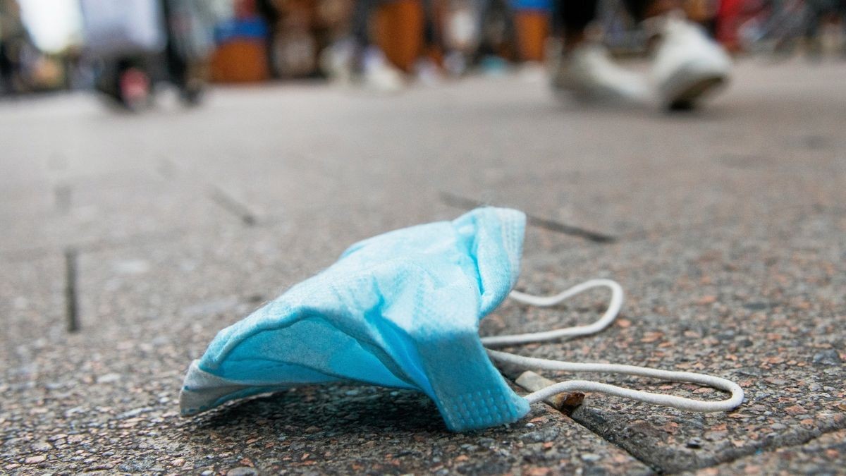 Eine Maske liegt in der Innenstadt auf dem Boden. Klinik-Besucher sollten mancherorts vorsorglich wieder eine einstecken haben.