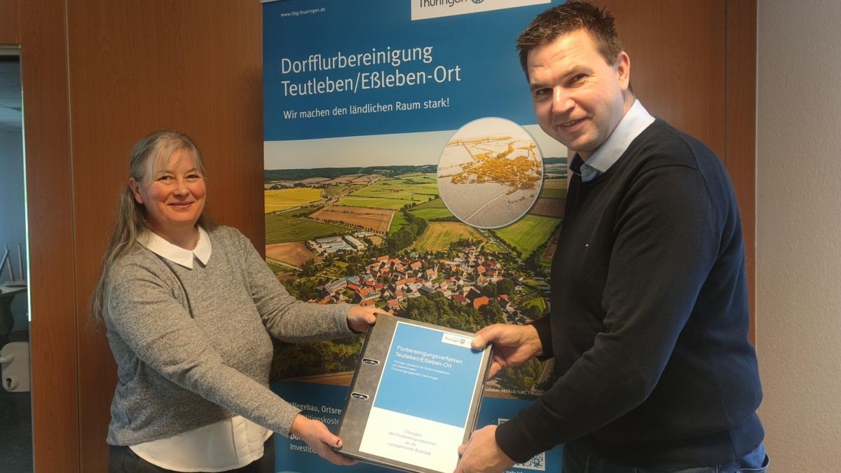 Frauke Anders, Referatsbereichsleiterin im Thüringer Landesamt für Bodenmanagement und Geoinformation, übergibt Hendrik Blose, dem Bürgermeister der Landgemeinde Buttstädt, die Schlussfeststellung.