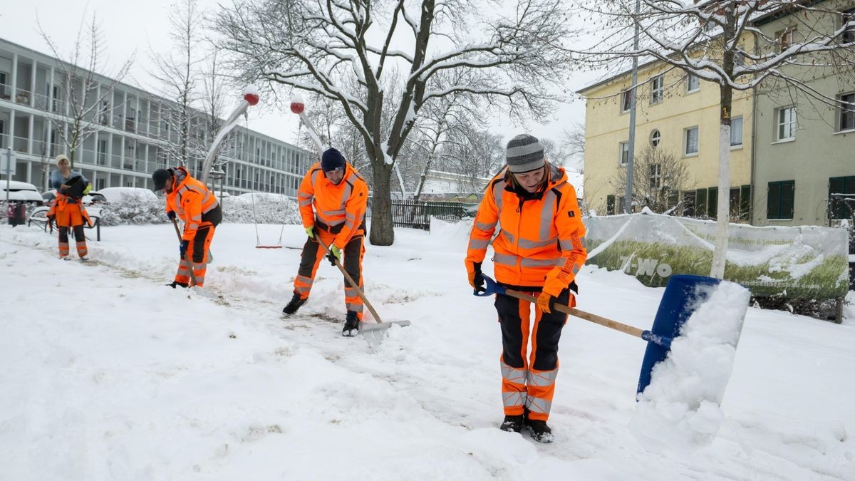 Mitarbeiter vom Erfurter Garten- und Friedhofsamt befreien am Nachmittag Gehwege vom Schnee.