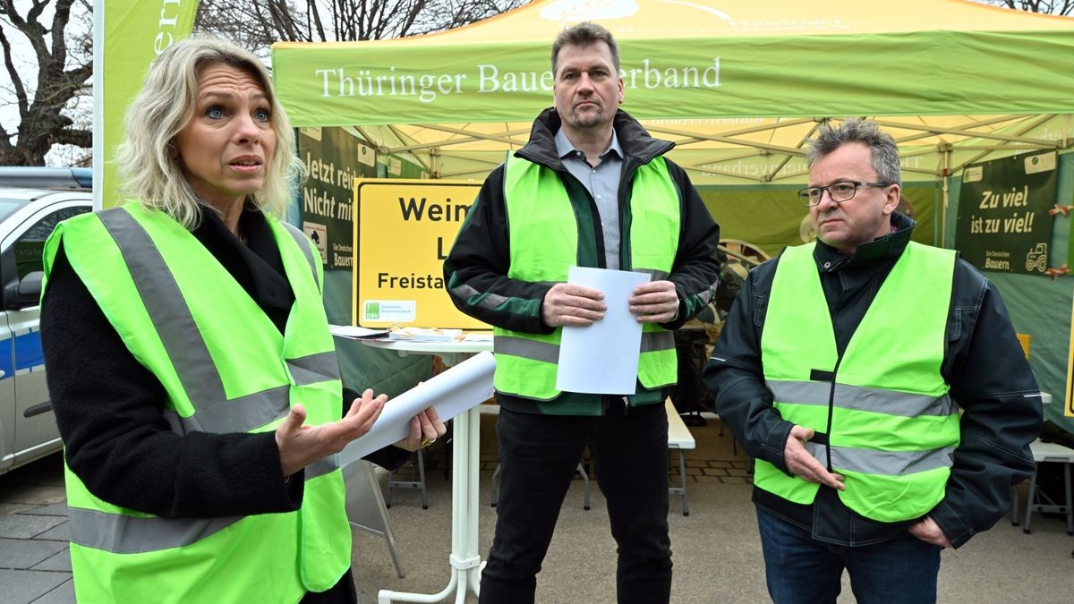 Susanna Karawanskij (links, Linke), Landwirtschaftsministerin von Thüringen, spricht mit Lars Fliege (Mitte), Vizepräsident, und Klaus Wagner (rechts), Präsident des Thüringer Bauernverbandes, und demonstrierenden Landwirten vor dem Thüringer Landtag.