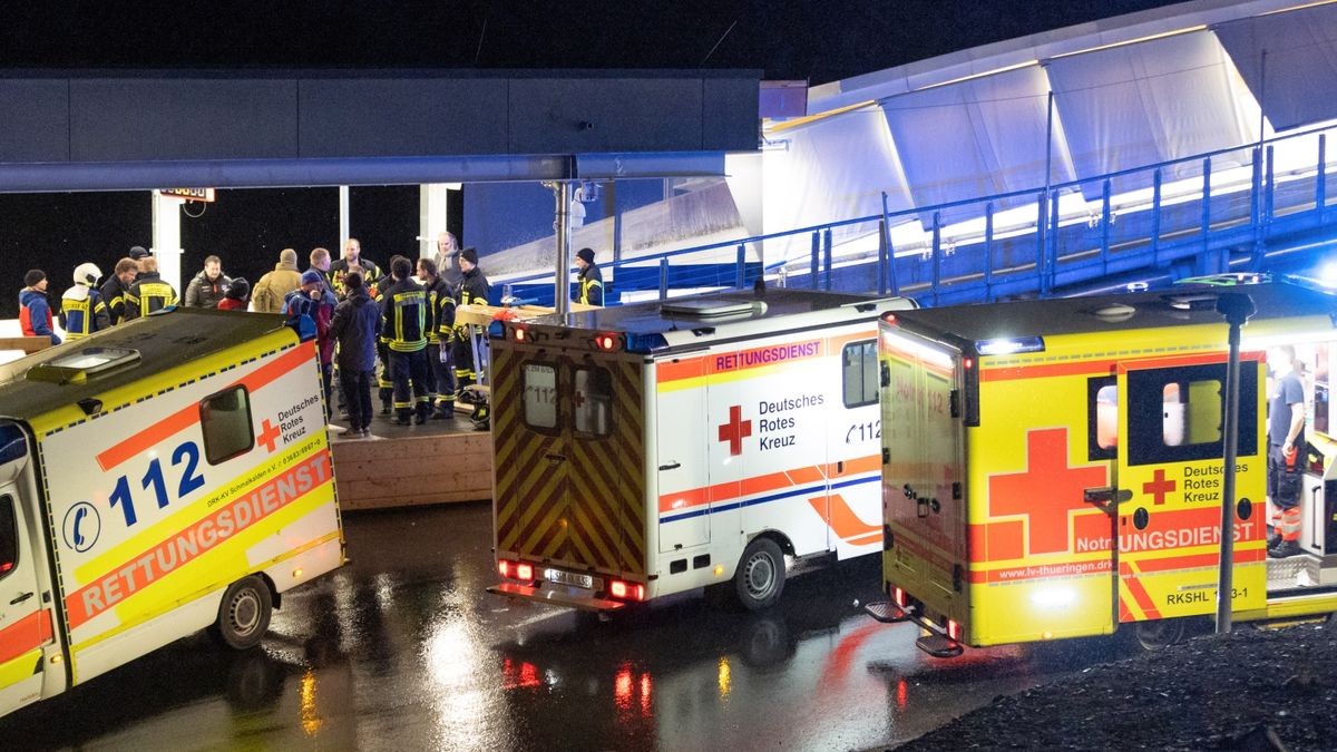 Rettungswagen und Helfer stehen am Abend des 23. Februar 2023 am Ausgang der Bobbahn. Einsatzkräfte bemühen sich um die Opfer des Zusammenpralls zwischen einem Bob und dem Ice-Tube.