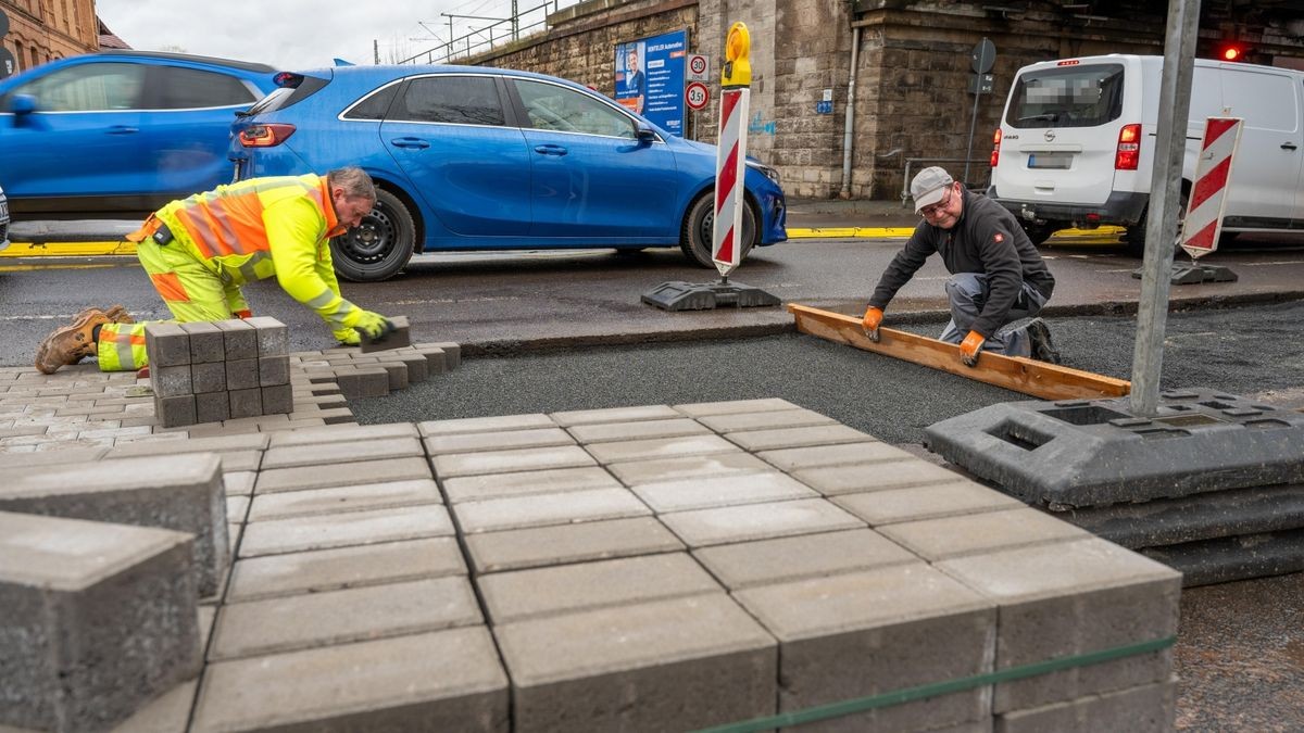 Thomas Reißig (links) und Frank Coppi von der Firma Bauservice aus Moorgrund bereiten die Öffnung der Straße aus Richtung Westen vor und gleichen die Höhe an die Hospitalstraße an.