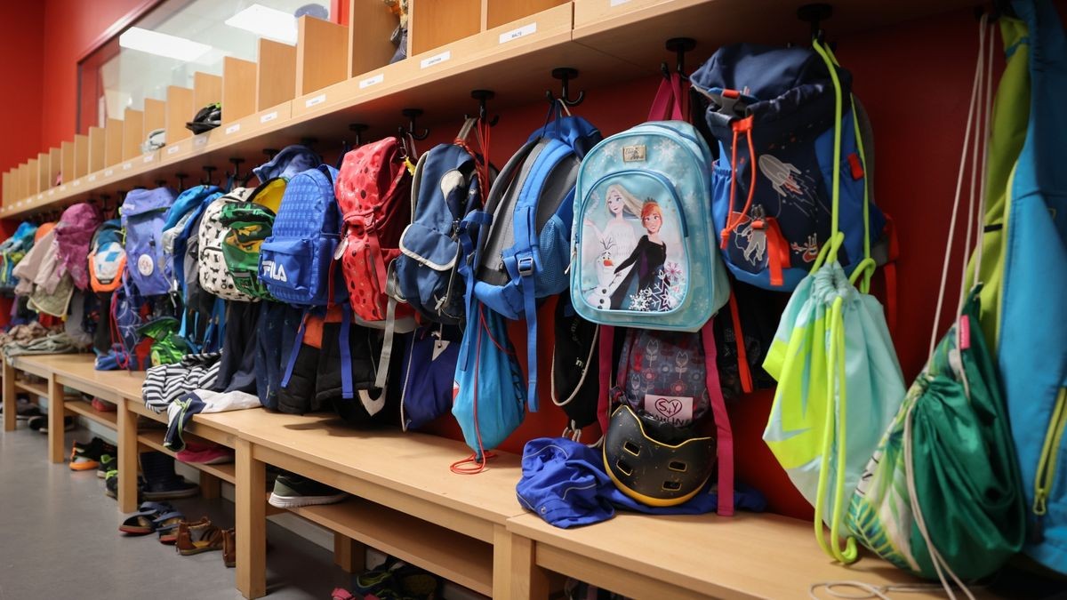 Sporttaschen und Schulranzen hängen an der Garderobe vor einem Klassenzimmer einer Grundschule (Symbolbild)