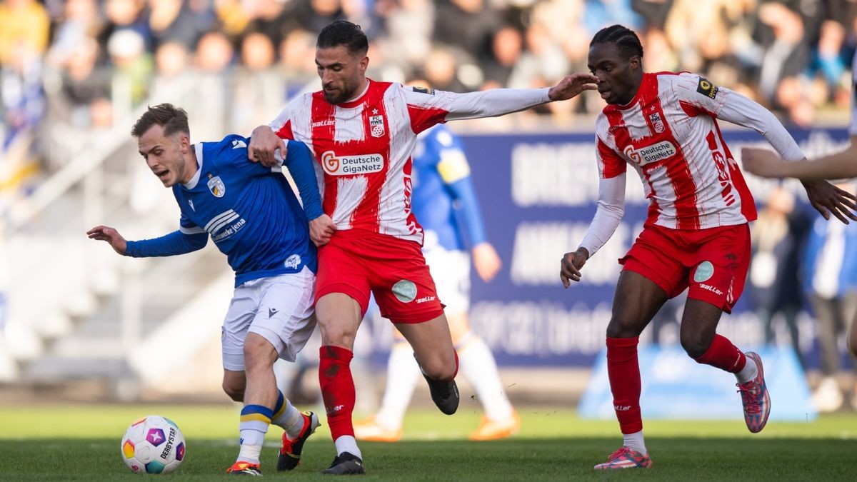 Erfurts Romarjo Hajrulla (Mitte) versucht Jenas Justin Petermann (links) den Ball abzujagen.