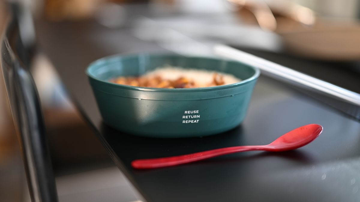 Eine Mehrwegschüssel steht mit Essen gefüllt auf einem Tisch.