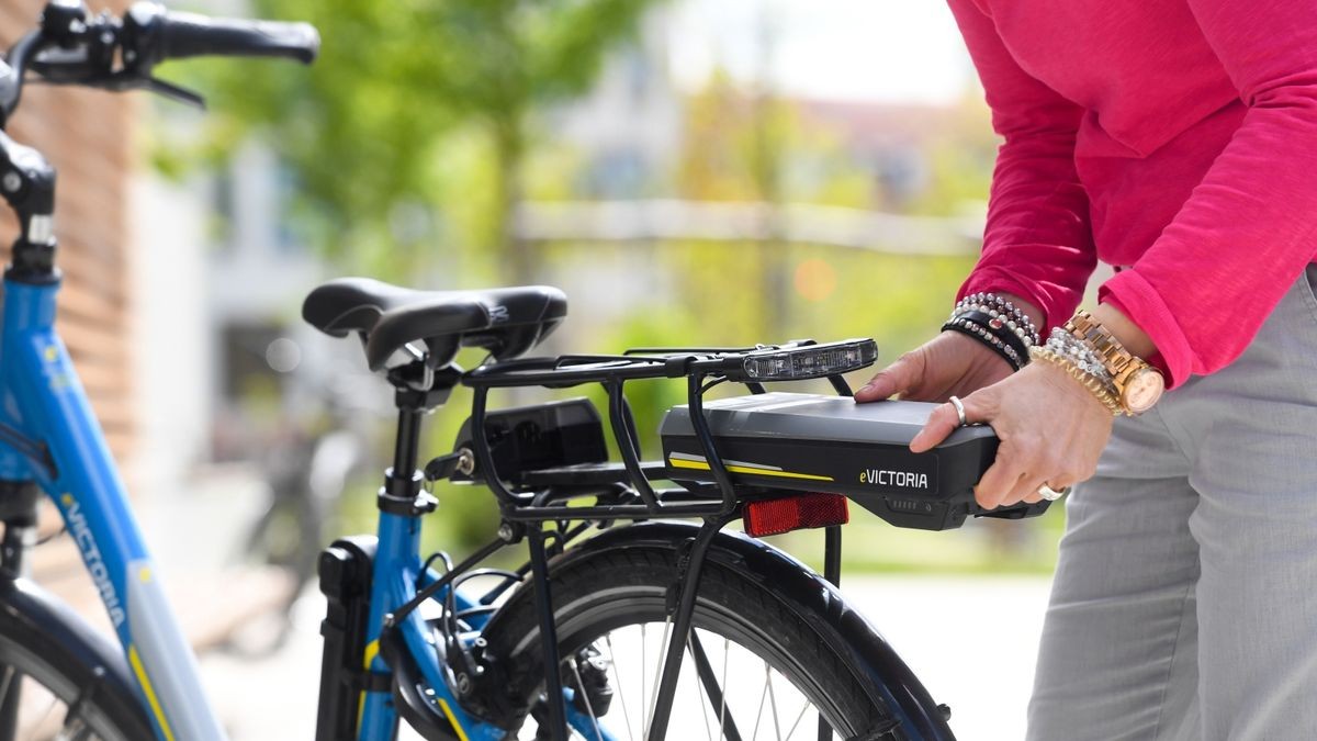 Eine Frau nimmt den Akku eines E-Bikes ab. Der Elektro-Antrieb hat längst das Fahrrad erobert. Egal, ob Mountainbike oder Lastenrad - immer mehr Räder sind motorisiert.