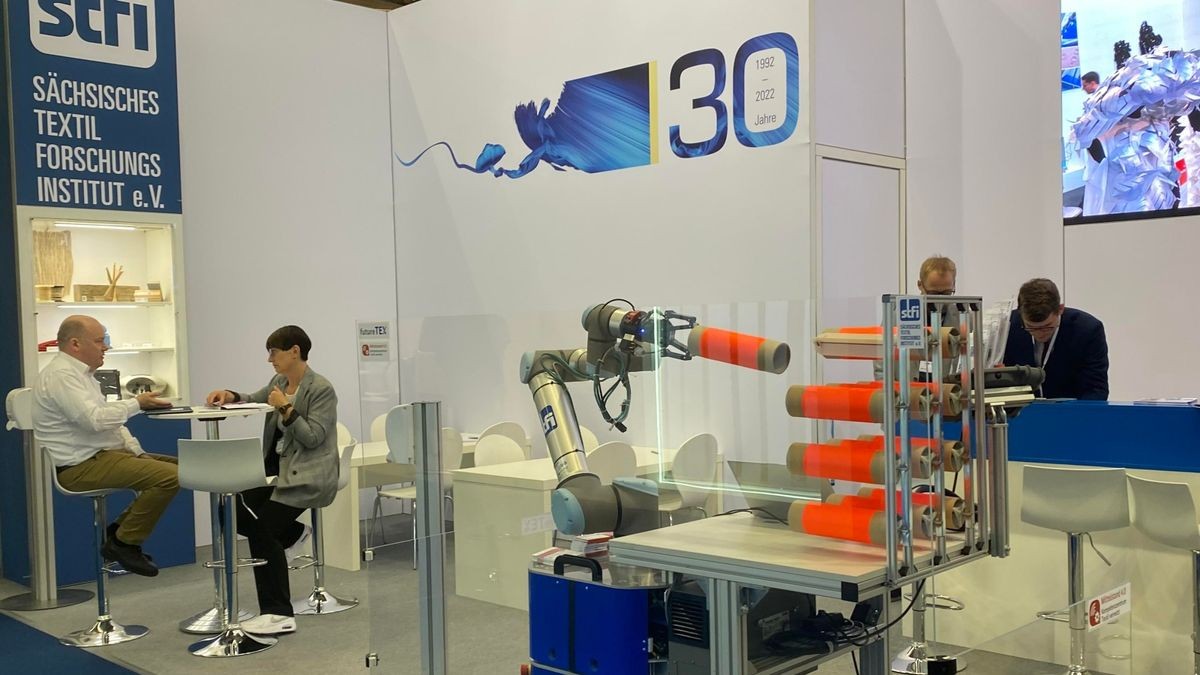 Ein mobiles Robotersystem zur automatisierten Bestückung eines Spulengatters auf der Messe Techtextil 2022.