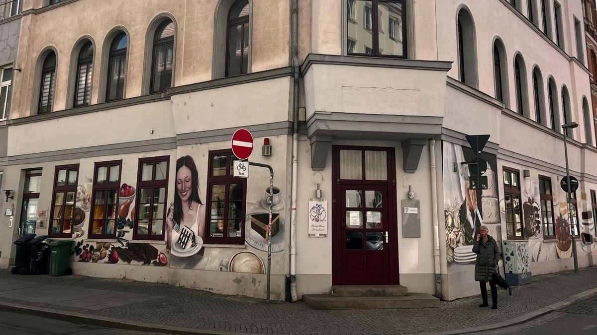 Die Fassade der Johannesstraße 19 ist seit 15 Jahren mit Torten, Obst, Kakao, Kaffeegeschirr und einer jungen Frau bemalt.