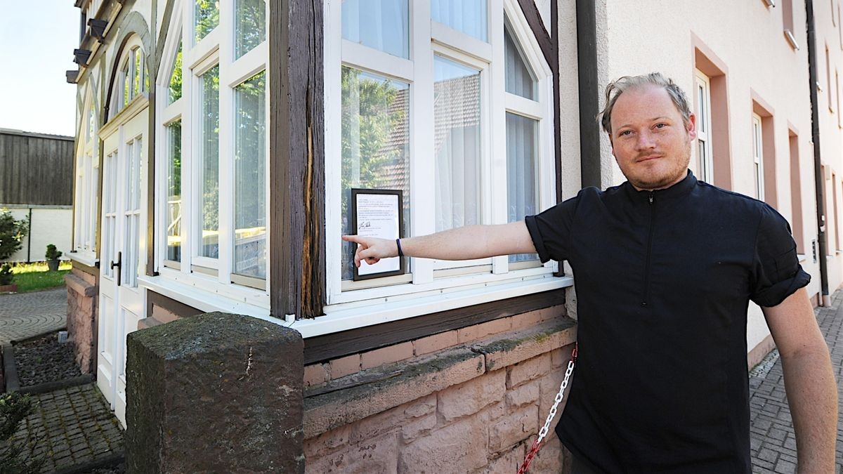 Alexander Simmes zeigt auf einen morschen Holzbalken auf der Rückseite des Gebäudes.