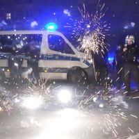 Polizeibeamte stehen am Silvesterabend hinter explodierendem Feuerwerk. Vergangenes Silvester kam es vor allem in Berlin zu Ausschreitungen. (Archivbild) Silvester in Berlin