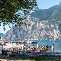 Der Gardasee zieht besonders im Sommer viele Touristen an. Nun wurde das noch kühle Wasser einem Mann aus Deutschland zum Verhängnis. Torbole, Lake Garda, Italy - 7 August 2023: Vacation on Lake Garda, numerous tourists and vacationers sunbathe on the no