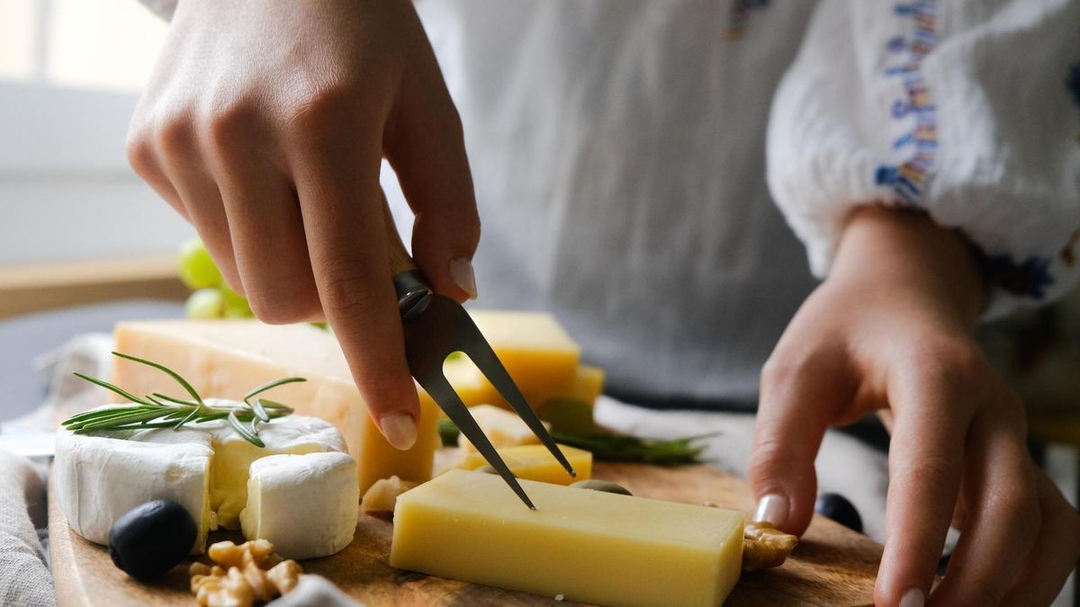 Frau schneidet Käse